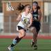 Huron's Mariel Ward cradles the ball as she drives down field during the first half of Huron's game against East Lansing on Thursday, May 2.
Courtney Sacco I AnnArbor.com   